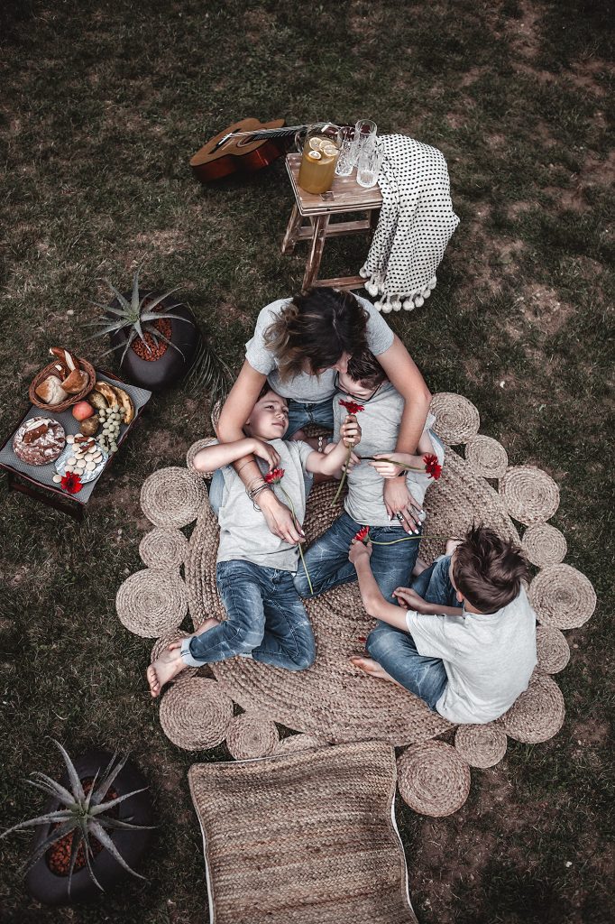 With these tips and decorative elements create a simple picnic decor in the garden and make the spot relaxing, familiar & inviting instantly. Family photo, mother and sons, picnic, garden, mother and kids, round jute rug.